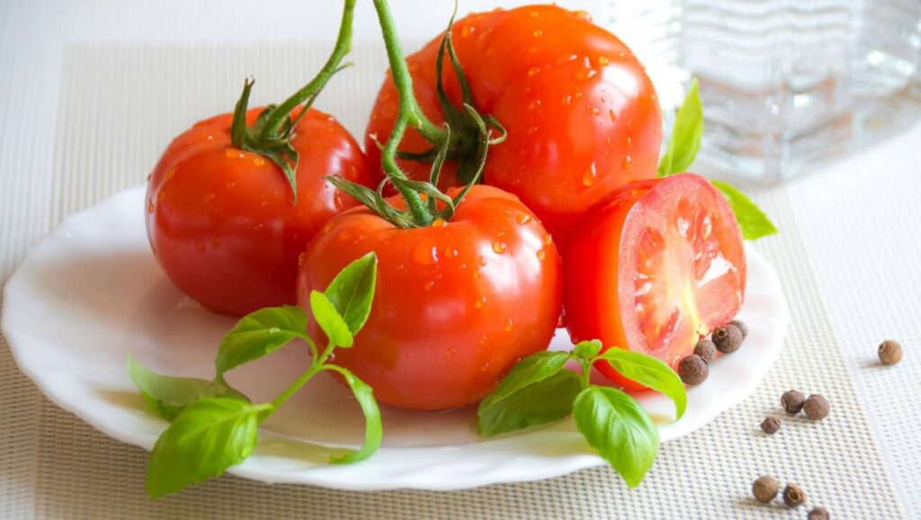 Four tomatoes are placed on a plate